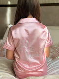 Luxury pink satin Christmas short pyjama set with white piping and sparkling crystal rhinestone ‘Let it snow’ lettering on the back, by Niamh Avenue.